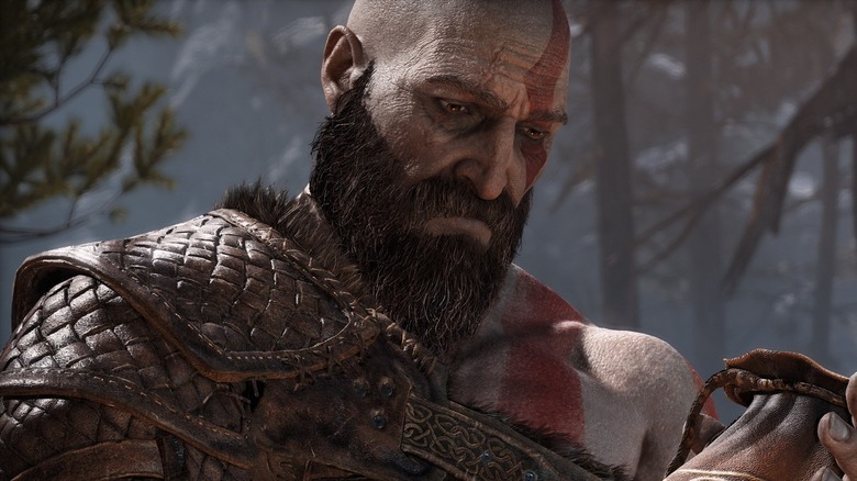 Kratos holding an amulet with melancholy in God of War