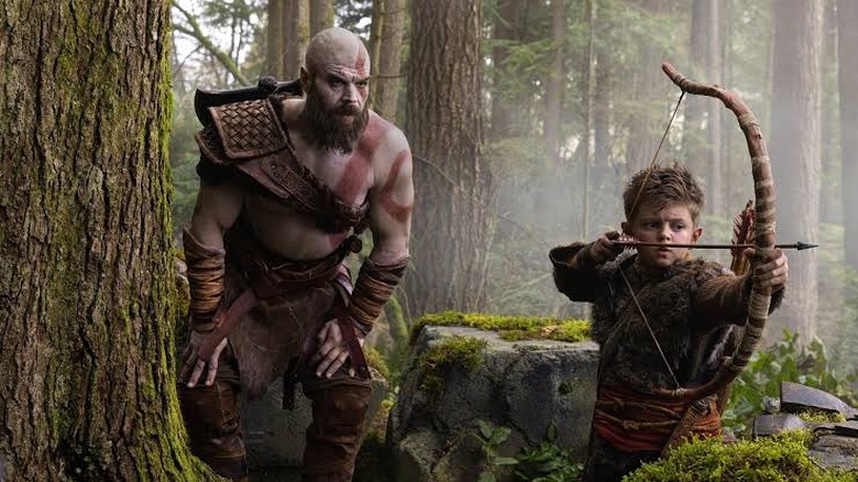Ryan Hurst as Kratos watching Callum Vinson as Atreus get ready to fire his bow and arrow in the God of War TV show