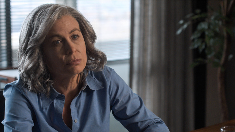 Sonya Walger as Molly Cobb sitting at a desk and looking morosely in For All Mankind