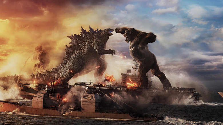 godzilla and king kong facing off with next to a destroyed bridge