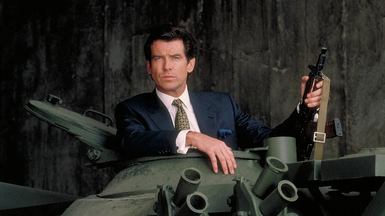Pierce Brosnan as James Bond popping out of the top of a tank holding an AK-47 in GoldenEye