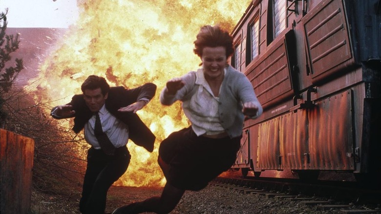 Pierce Brosnan as James Bond and Izabella Scorupco as Natalya Simonova jumping from an explosion on the train in GoldenEye
