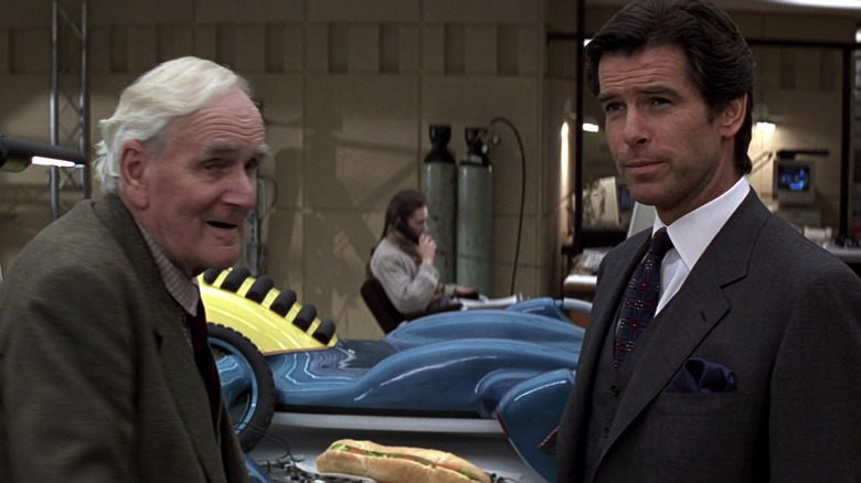 Pierce Brosnan as James Bond standing with Desmond Llewelyn as Q in his lab in GoldenEye