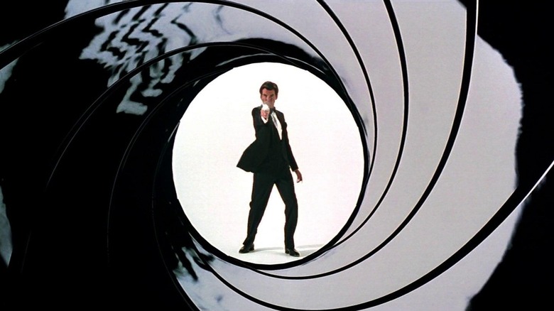 Pierce Brosnan as James Bond shooting his gun at the screen in the gun barrel sequence in GoldenEye