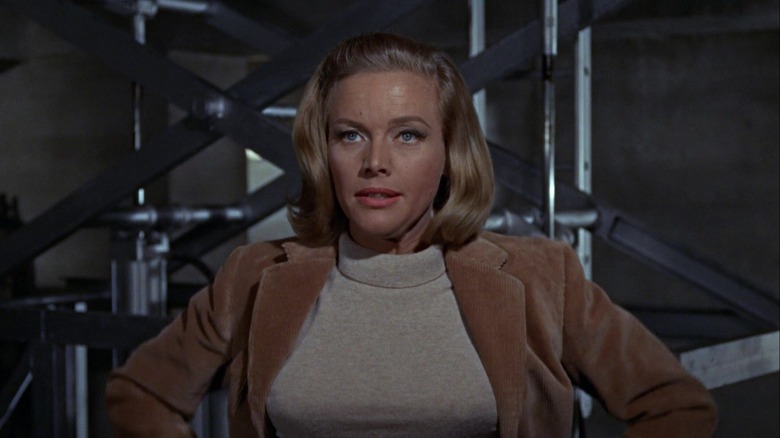 Honor Blackman as P***y Galore stands with her hands on her hips in Goldfinger