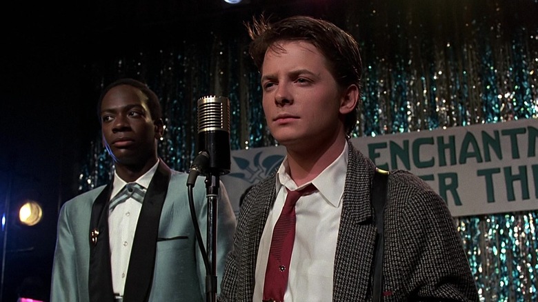 Marvin Berry and Marty McFly standing in front of a microphone in Back to the Future