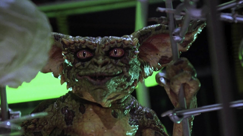 A Gremlin looking at something off camera and bathed in green backlight in "Gremlins 2: The New Batch"