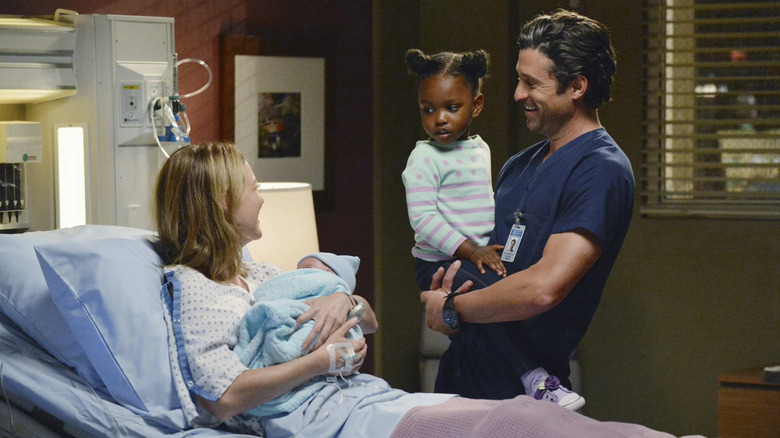 Meredith holding Bailey and Derek holding Zola in a hospital room on Grey's Anatomy