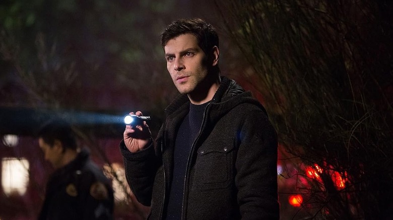 David Giuntoli as Detective Nicholas "Nick" Burkhardt holding a flashlight in Grimm
