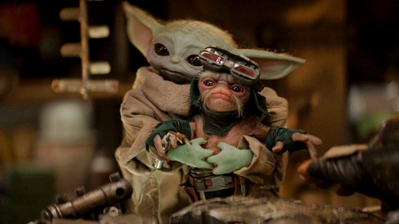 Grogu holding an Anzellan droid smith in The Mandalorian