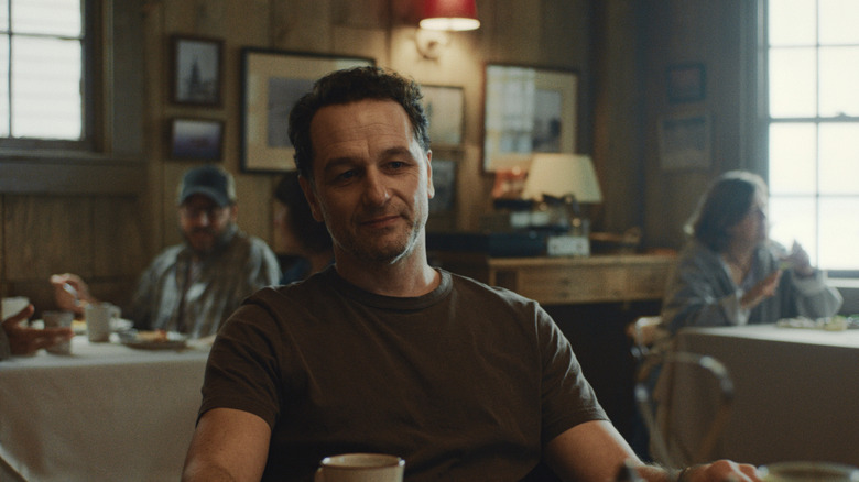 Tom Loftis smiles at someone offscreen in Widow's Bay