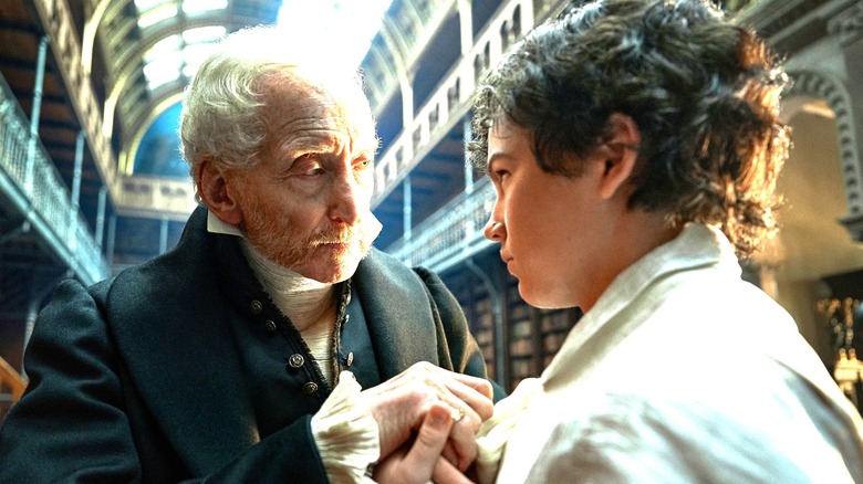 Frankenstein, Alphonse Frankenstein and young Victor Frankenstein touching hands in a library