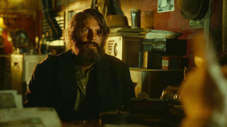Bradley Cooper als Stan Carlisle die er verfomfaaid uitziet met een baard in Nightmare Alley