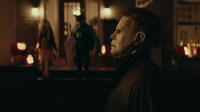 Michael Myers (James Jude Courtney) stands stoically as two trick-or-treaters approach in Halloween (2018)