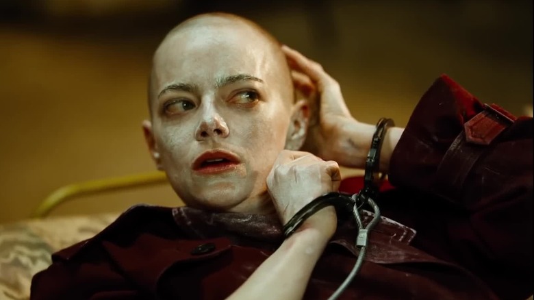 Emma Stone as Michelle covered in cream handcuffed to the bed in Bugonia