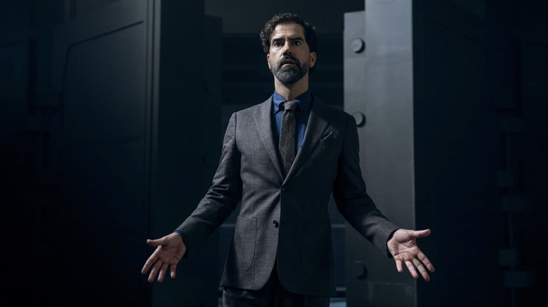 Hamish Linklater as Cipher in Gen V, wearing a suit with his arms spread