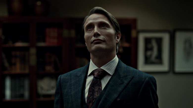 Mads Mikkelsen as Hannibal Lecter in his office looking upward on NBC's Hannibal