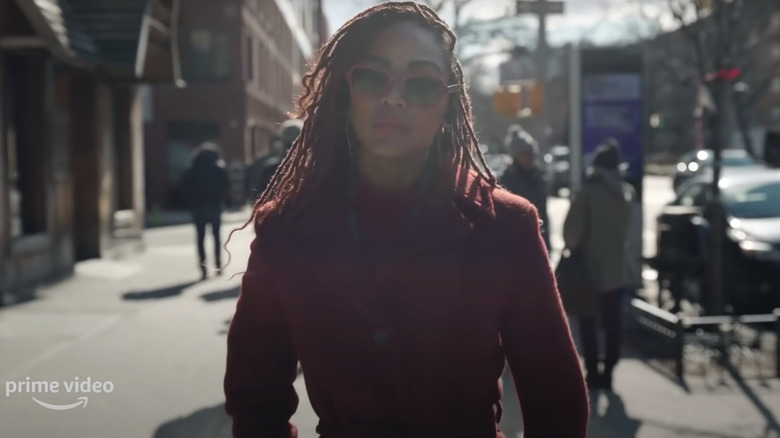 Camille walks down a sunny NYC sidewalk