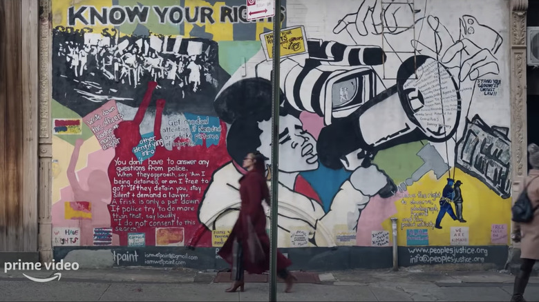 Camille (Megan Good) passes a mural as she walks through Harlem