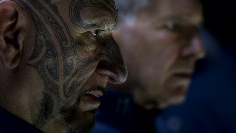 Ben Kingsley's Mazer Rackham is seen in closeup as he stands beside Harrison Ford's Colonel Hyrum Graff in Ender's Game