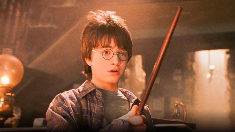 Harry looing at his new wand bathed in light in Harry Potter and the Sorcerer's Stone