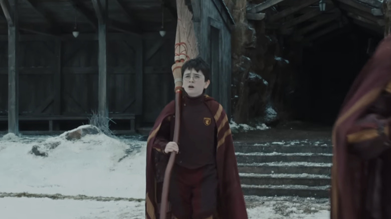Harry Potter carrying a Quidditch broomstick in Harry Potter and the Philosopher's Stone
