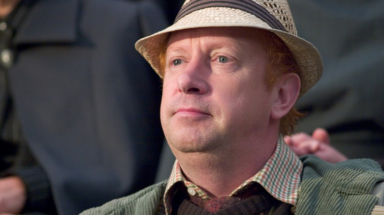 Arthur Weasley (Mark Williams) sits in the stands with a sporty hat in Harry Potter and the Goblet of Fire