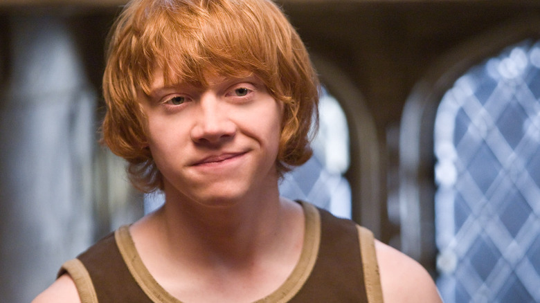 Ron Weasley (Rupert Grint) smirks wearing a tank top in Harry Potter and the Goblet of Fire
