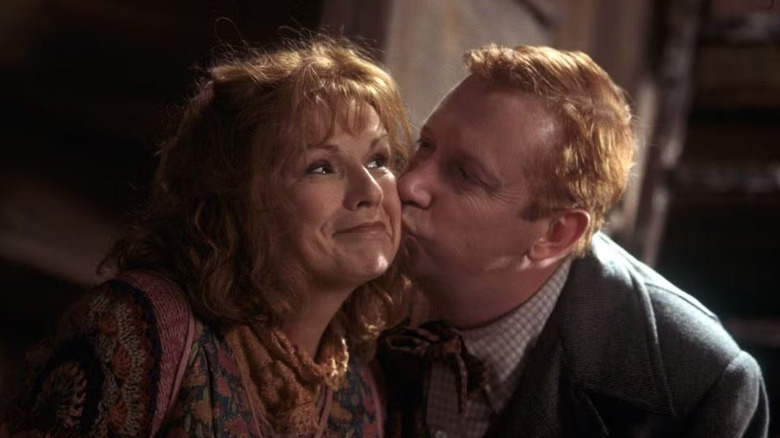 Julie Walters as Molly Weasley and Mark Williams as Arthur Weasley in Harry Potter and the Chamber of Secrets, with Arthur giving Molly a kiss on the cheek.