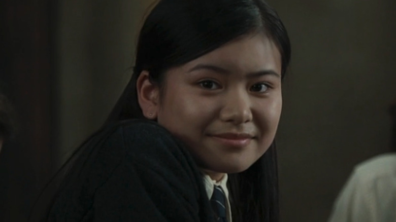 Katie Leung as Cho Chang in Harry Potter and the Goblet of Fire, giving a slight smirk while looking off at something.