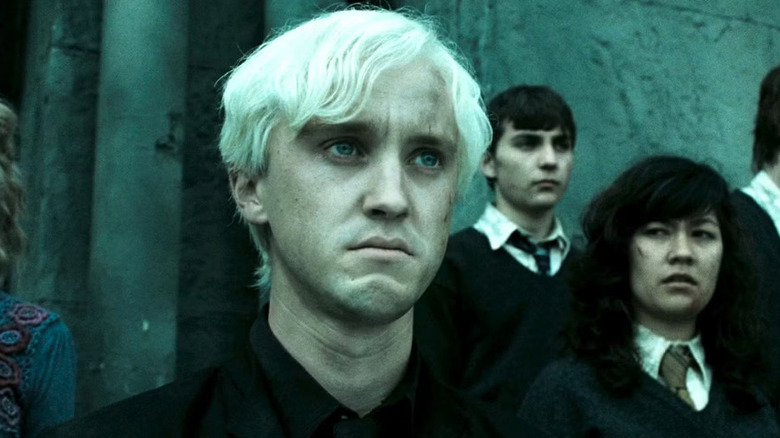 Tom Felton as Draco Malfoy in Harry Potter and the Deathly Hallows: Part 2, standing and looking off past the frame.
