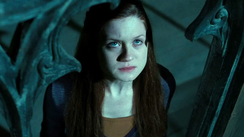 Bonnie Wright as Ginny Weasley in Harry Potter and the Deathly Hallows: Part 2, looking up at the sky with concern.