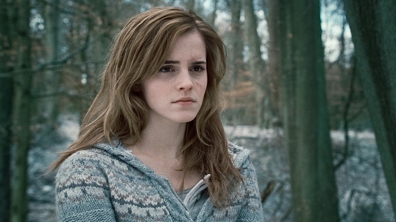 Emma Watson as Hermione Granger in Harry Potter and the Deathly Hallows: Part 1, looking somber while looking on at someone.