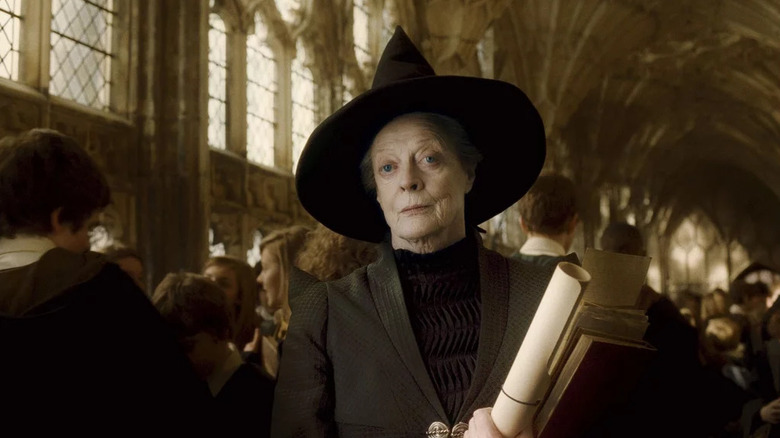 Maggie Smith as Minerva McGonagall in Harry Potter and the Half Blood Prince, standing and looking slightly stern in a hallway full of students.