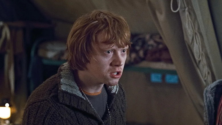 Rupert Grint as Ron Weasley in Harry Potter and the Deathly Hallows: Part 1, looking concerned while looking at someone.