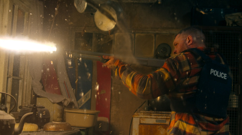 Tom Hardy's Walker blasts a shotgun out of a window in Havoc