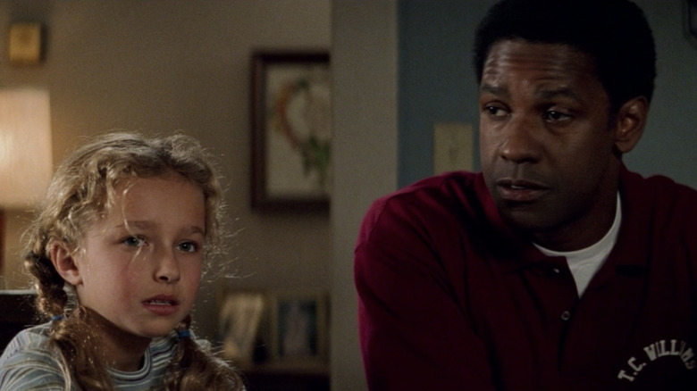 Hayden Panettiere as Sheryl Yoast sitting at a dinner table next to Denzel Washington as Herman Boone in Remember the Titans