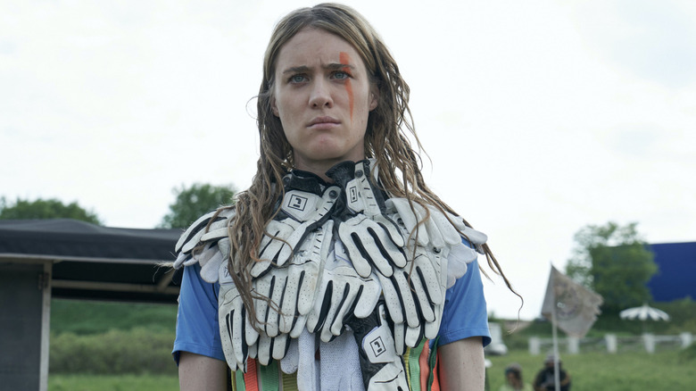 Mackenzie Davis as Kristen covered in golf gloves with red face paint in Station Eleven