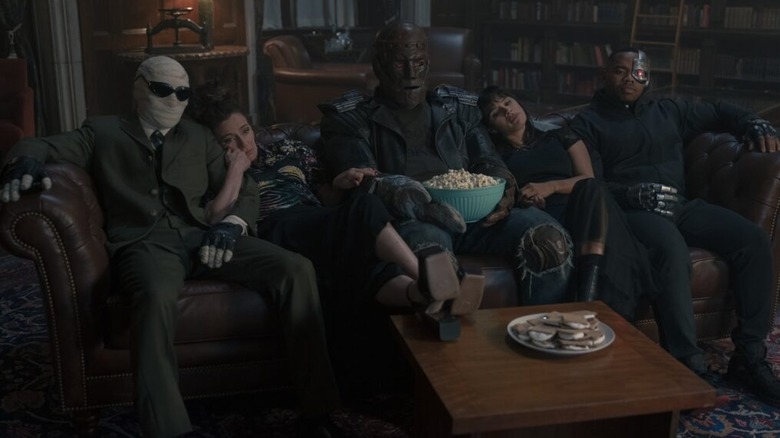 The Doom Patrol relaxes on a couch watching TV