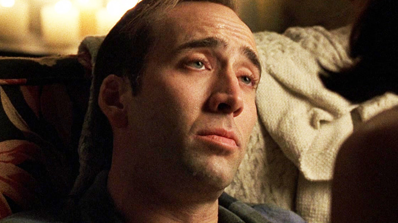 Nicolas Cage's Stanley Goodspeed is seen in closeup as he sits on a couch in The Rock