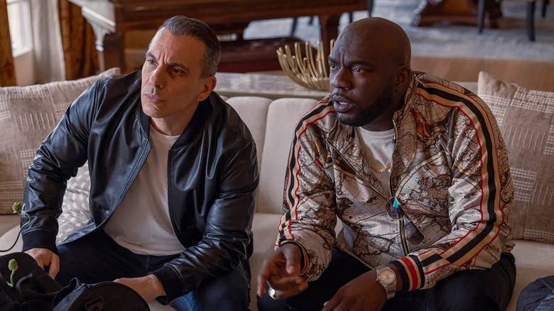 Sebastian Maniscalco and Omar Dorsey as Danny and Ray sitting on a couch in Bookie