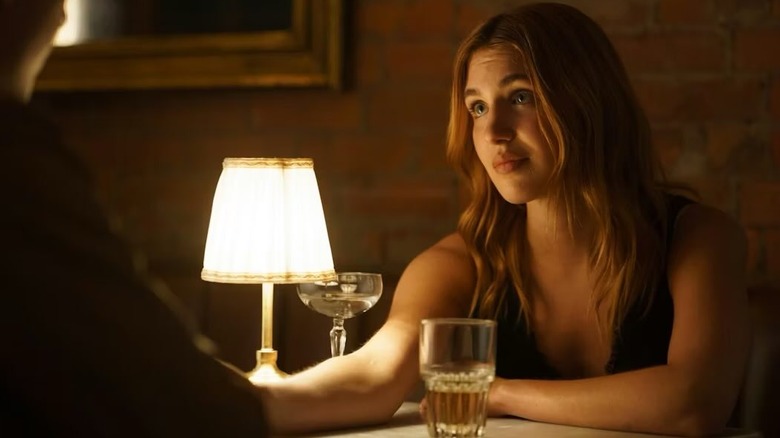 Sophie Nelisse as Rose Landry sitting at a table in Heated Rivalry