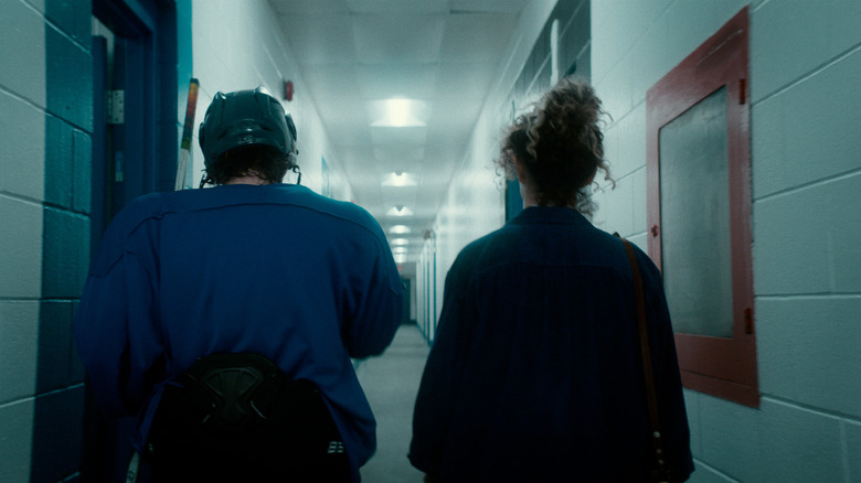 Harrison Browne as Scott and Nicolette Pearse as Laura standing in a hallway in Pink Light