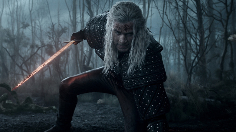 Geralt kneeling down and holding a sword on The Witcher