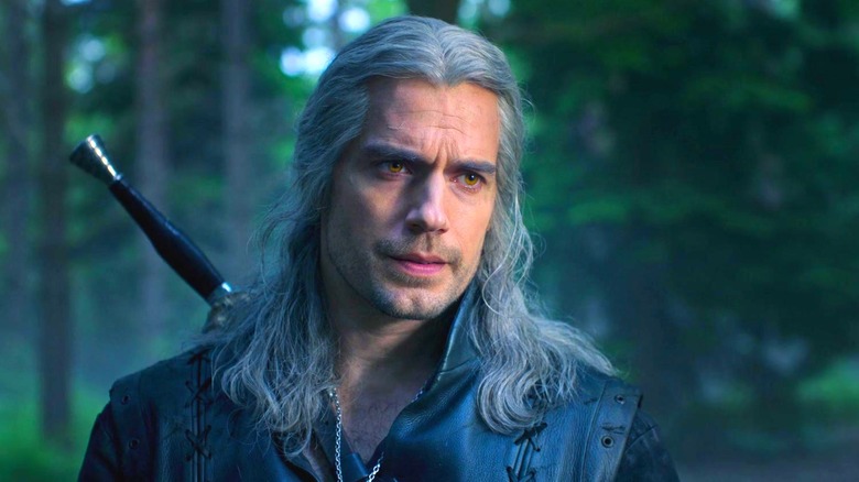 Henry Cavill as Geralt of Rivia looking displeased in a forest on The Witcher