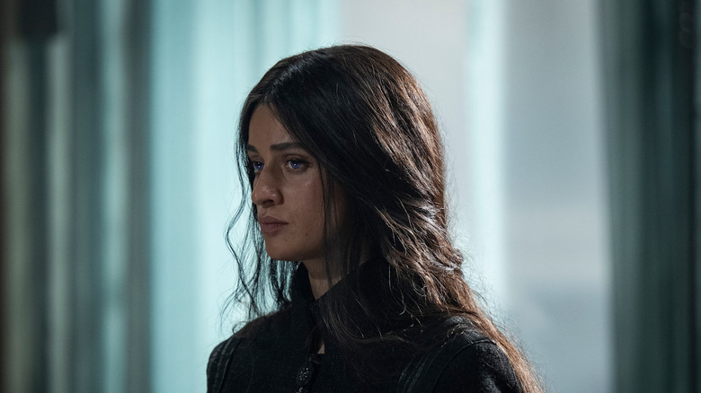 Anya Chalotra's Yennefer stands against a blurred background in The Witcher