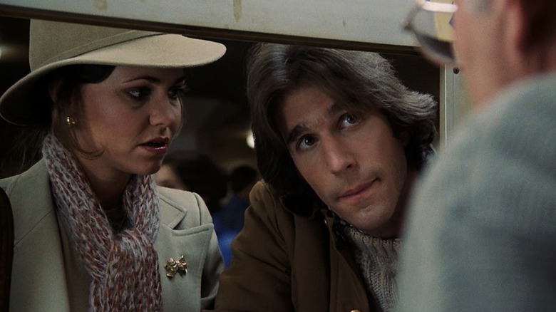 Carol (Sally Field) memakai topi dan syal, tampak prihatin seperti Jack (Henry Winkler), mengenakan jaket cokelat, bersandar pada berwajah lurus untuk berbicara dengan agen tiket di Heroes