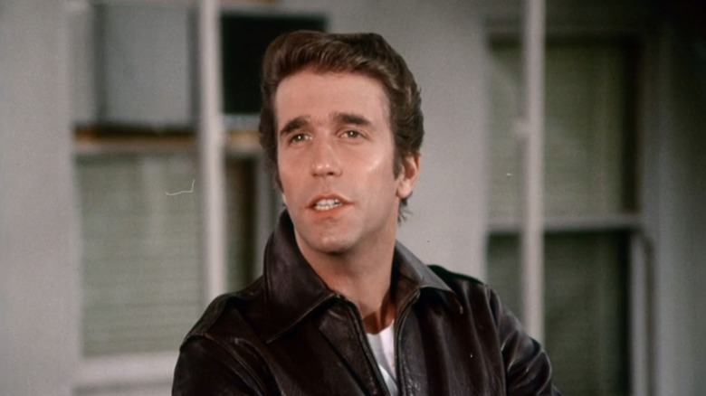 Henry Winkler's Arthur Fonzarelli is seen in closeup with two windows in the background in Happy Days