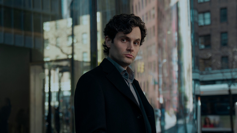 Joe outside of a glass building staring in You