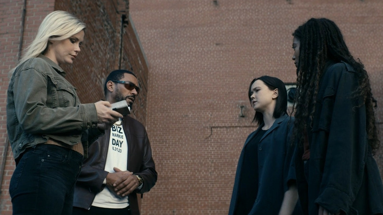 Erin Moriarty as Annie January/Starlight and Laz Alonso as MM standing opposite London Thor as Jordan Li and Jaz Sinclair as Marie Moreau in front of a brick building in The Boys